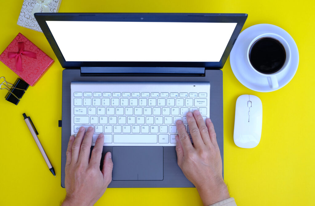 Young Indian freelance writer working on a laptop at a home desk with books, coffee, and natural daylight, representing online writing jobs and blogging opportunities in India in 2025.